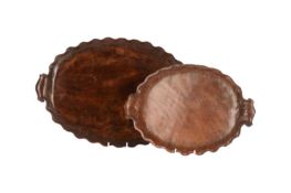A nearly 20th-century walnut hand-carved oval tray with a scalloped oval outline and a pair of scrol