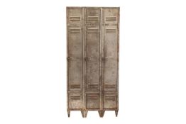 A vintage industrial brushed steel three-door gym locker, with vented doors and squat angular feet. 