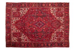 A large red ground Heriz carpet, 20th century, with a typical geometric central medallion within a t