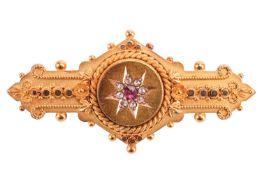 A Victorian mourning brooch in 15ct yellow gold, of Etruscan Revival design, star motif centred in t