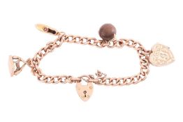 A 9ct gold charm bracelet, featuring four charms including a heart locket, a gem-set shoe and other 