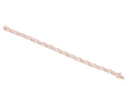 A diamond-set bracelet, with curved links featuring a floral design, set with baguette-cut and round