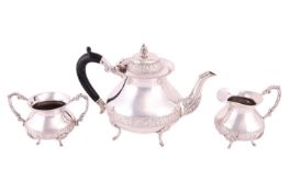 A three-piece tea set of circular low-bellied form, with floral and foliate embossed borders, compri