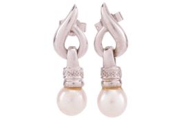 A pair of cultured pearl drop earrings, featuring 7mm cream/pink pearl drops on white metal testing 