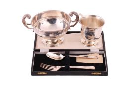 A silver christening mug with threaded decoration on a flared foot, a silver sugar bowl with reeded 