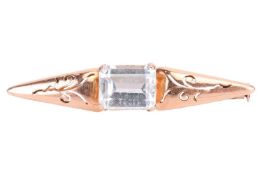 An aquamarine bar brooch, centred with an emerald-cut aquamarine of 8.9 x 7.0 x 5.2 mm, claw-set to 