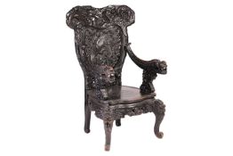 A Chinese ebonised carved wood armchair, late 19th/ early 20th century, the top rail in the form of 