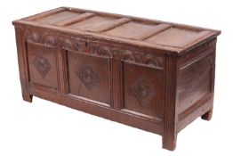 A 17th century carved oak (?) three-paneled coffer, a molded four-panel top above a lunette carved f