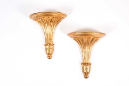 A pair of giltwood wall brackets of classical style, of volute fanned form with demi-lune plinths ab