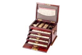 An Edwardian mahogany case Chinese Mahjong set with pen worked bone and bamboo tile, The fitted case