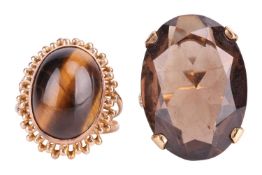 Two gem-set dress rings; the oval tiger's eye cabochon in collet measures 15.5 x 11.5 mm, in a wire 