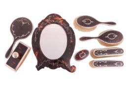 An Edwardian silver-mounted tortoiseshell dressing table set, a tortoiseshell dressing table mirror 