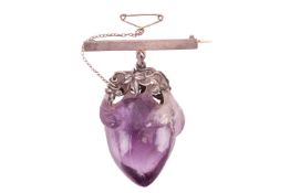 A carved amethyst peach later set on a bar brooch, featuring a large Chinese plump peach and its lea