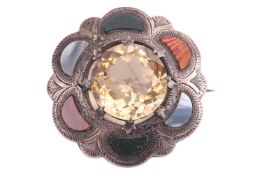 A Scottish hardstone brooch set with a large faceted citrine, to a scalloped surround adorned with p