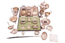 A quantity of silver including cream jugs, napkin rings, condiment pieces, a silver mounted pepper g