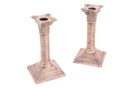 A pair of silver candlesticks, of Corinthian column form with detachable sconces, on stepped weighte
