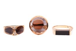 Three rings; comprising a smoky quartz cocktail ring, the tapered gemstone bezel-set in a yellow met