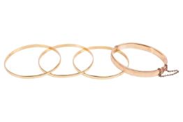 A set of three closed bangles and another; the closed bangles in yellow metal stamped '18ct', 6.3 cm