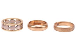 Three band rings; comprising a pierced heart ring in 18ct bi-coloured gold, size L½, 6.3 mm wide; a 