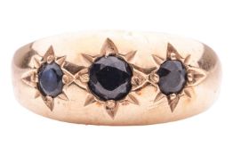 A sapphire three-stone ring, of tapered design, gypsy-set to the front with three slightly graduated