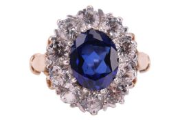 A synthetic sapphire and CZ cluster ring in 9ct gold, between fleur-de-lis shoulders to D-profile sh