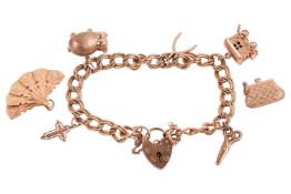 A 9ct gold charm bracelet, the double curb link bracelet leading to a heart-shaped padlock clasp, wi