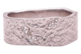 A planished dress ring, with undulating edges and bead-set with three diamond accents, in white meta