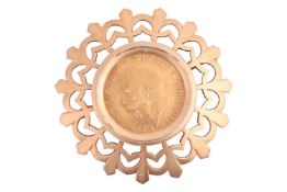 A George V half sovereign brooch, dated 1911, mounted in a circular pierced mount, in yellow metal t