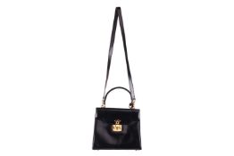 A Gucci black leather handbag, of plain tapering rectangular form and red leather interior, with a t