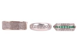 Three gem set rings; One emerald and diamond ring, channel set with nine table cut emeralds flanked 
