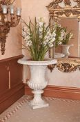 A PAIR OF CARVED MARBLE URNS ON PLINTHS IN NEO-CLASSICAL TASTE