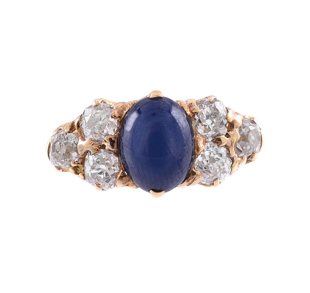 A DIAMOND AND SYNTHETIC STAR SAPPHIRE SEVEN STONE RING