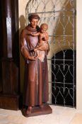 A LARGE CARVED AND STAINED WOOD FIGURE OF A SAINT HOLDING AN INFANT, SECOND HALF 20TH CENTURY