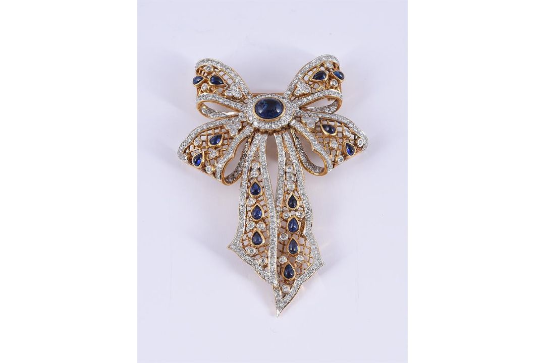 A SAPPHIRE AND DIAMOND PIERCED BOW BROOCH - Image 1 of 2