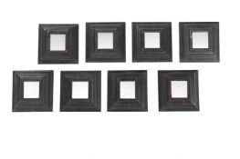 A SET OF NINE CUSHION FRAMED WALL MIRRORS