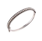 A LATE 19TH CENTURY SILVERED BANGLE SET WITH HALF PEARLS