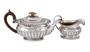 Y A GEORGE III SILVER LOBED OVAL TEA POT AND CREAM JUG
