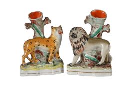 A PAIR OF STAFFORDSHIRE SPILL VASES MODELLED AS A LION AND A LEOPARD BEFORE A TREE, MID 19TH CENTURY