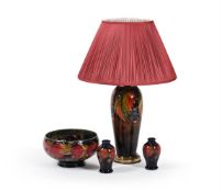 MOORCROFT POTTERY; THREE 'POMEGRANATE' PIECES AND A FLAMBÉ 'LEAF AND BERRY' LAMP; CIRCA 1925
