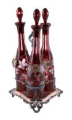 THREE RUBY-FLASHED AND ENGRAVED GLASS DECANTERS AND SILVER-PLATED STAND, CIRCA 1860