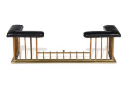 A POLISHED BRASS AND BLACK LEATHER UPHOLSTERED CLUB FENDER, FIRST HALF 20TH CENTURY