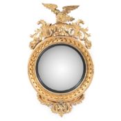 A REGENCY CARVED GILTWOOD CONVEX WALL MIRROR, CIRCA 1815