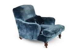 AN EDWARDIAN MAHOGANY AND UPHOLSTERED 'IVOR' ARMCHAIR BY HOWARD & SONS