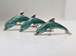 THREE SATURNO SILVER AND ENAMEL DOLPHINS