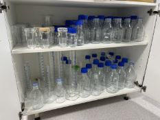 Qty of various glassware to cupboard including bottles, measuring funnels etc.