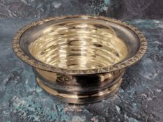 A silver wine bottle coaster, alternating foliage border, draught-turned base, 17cms dia., F Drury
