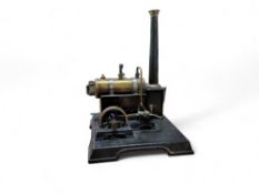 A Marklin brass and tin plate steam engine, with a single fly wheel, pressure gauge and chimney,