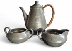 A Liberty Tudric Pewter three piece coffee service, hammered, wicker handle, the coffee pot 18cm