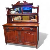 An Arts & Crafts walnut mirror backed sideboard, swan neck pediment super structure above shaped