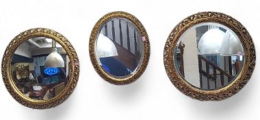 Three gilded mirrors, a convex to the left, oval to centre and bevelled to the right, the largest